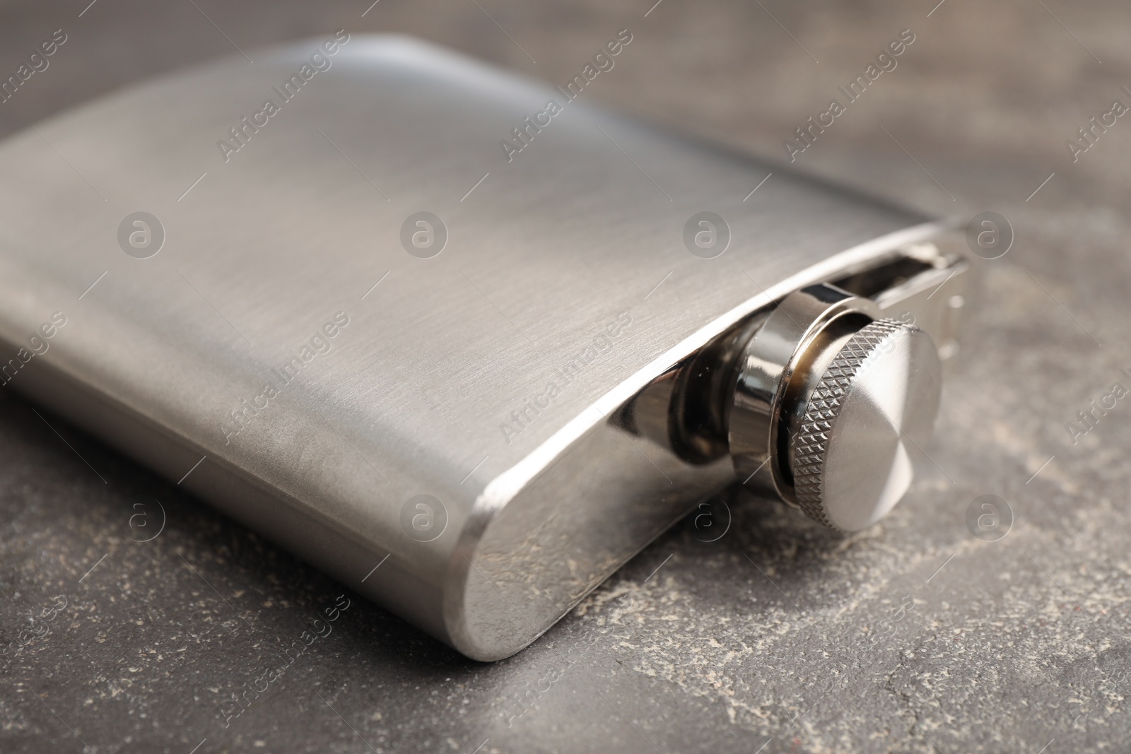 Photo of One hip flask on grey table, closeup