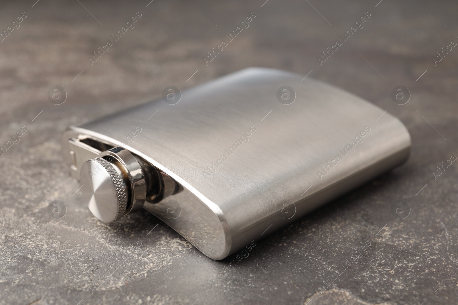 Photo of One hip flask on grey table, closeup