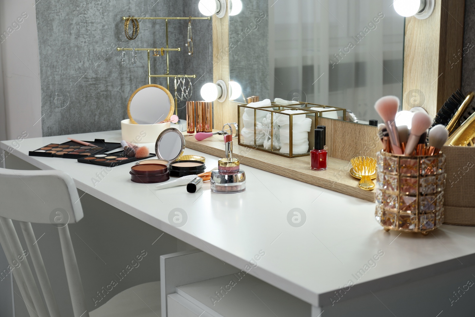 Photo of Makeup room. Different beauty products on white dressing table and mirror indoors