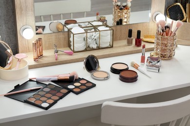 Photo of Makeup room. Different beauty products on white dressing table and mirror indoors