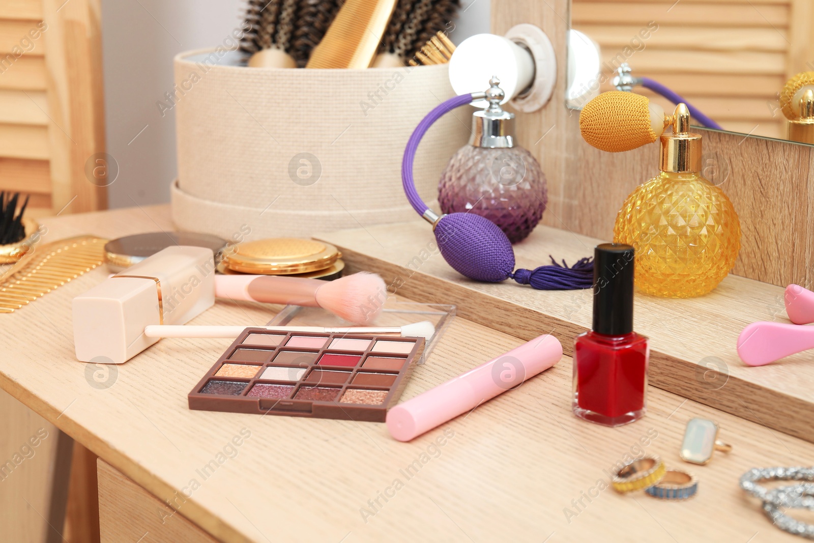 Photo of Makeup room. Different beauty products on wooden dressing table indoors, closeup