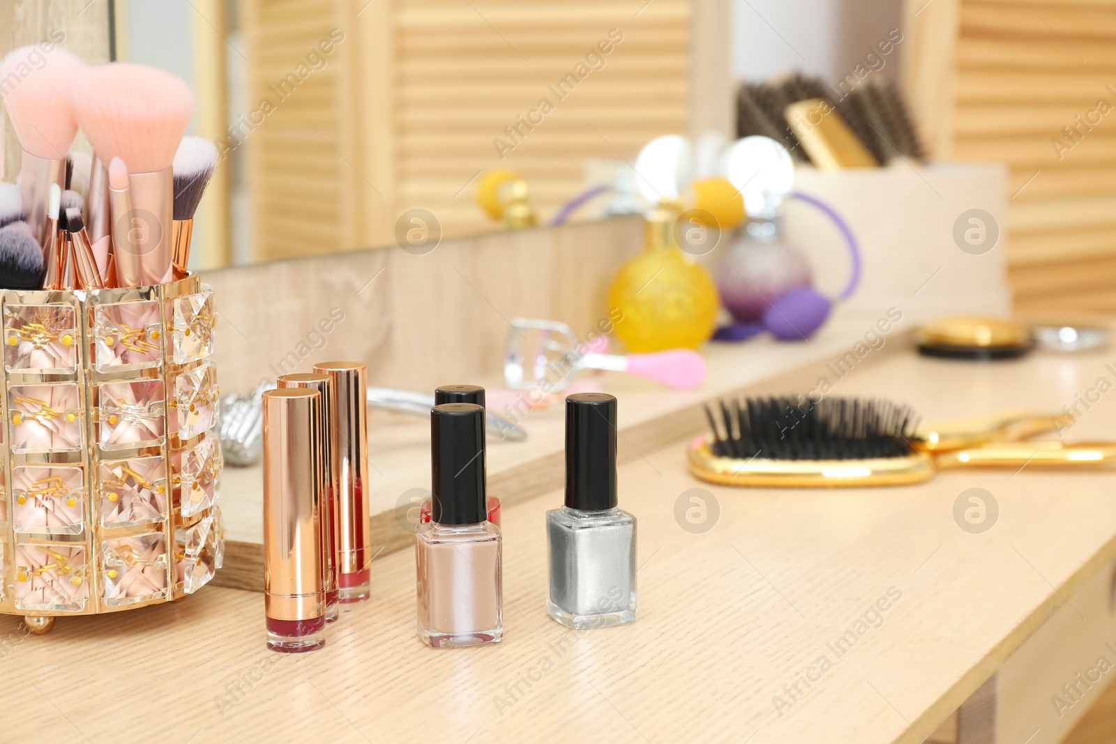 Photo of Makeup room. Different beauty products on wooden dressing table, closeup