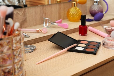 Photo of Makeup room. Different beauty products on wooden dressing table, closeup