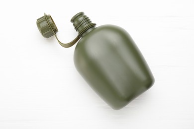 Photo of Green plastic canteen on white wooden table, top view