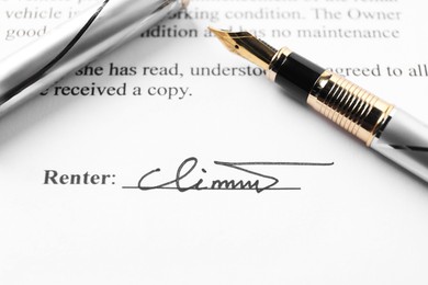 Photo of Signature and fountain pen on paperwork, closeup view