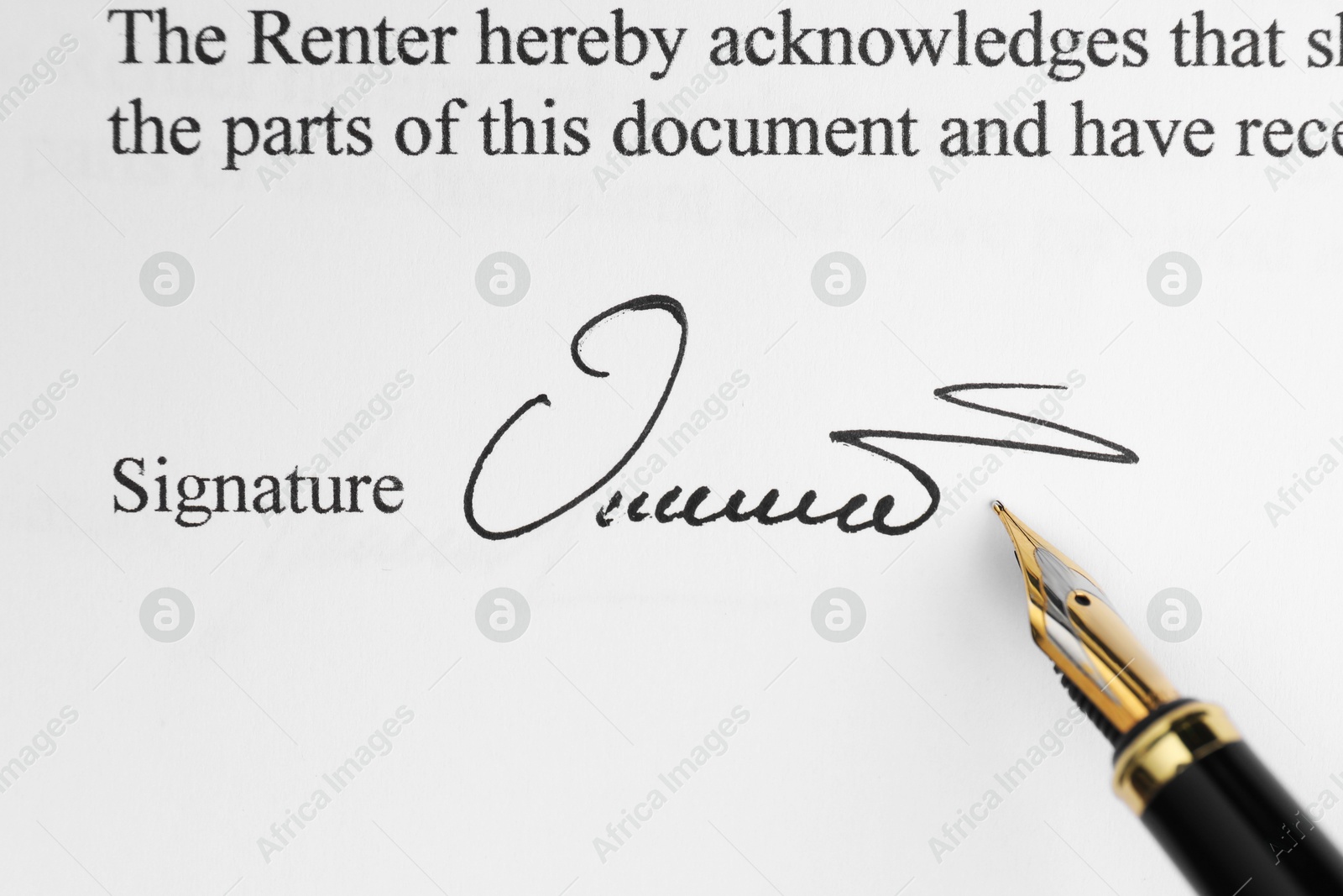 Photo of Fountain pen leaving signature on contract, top view