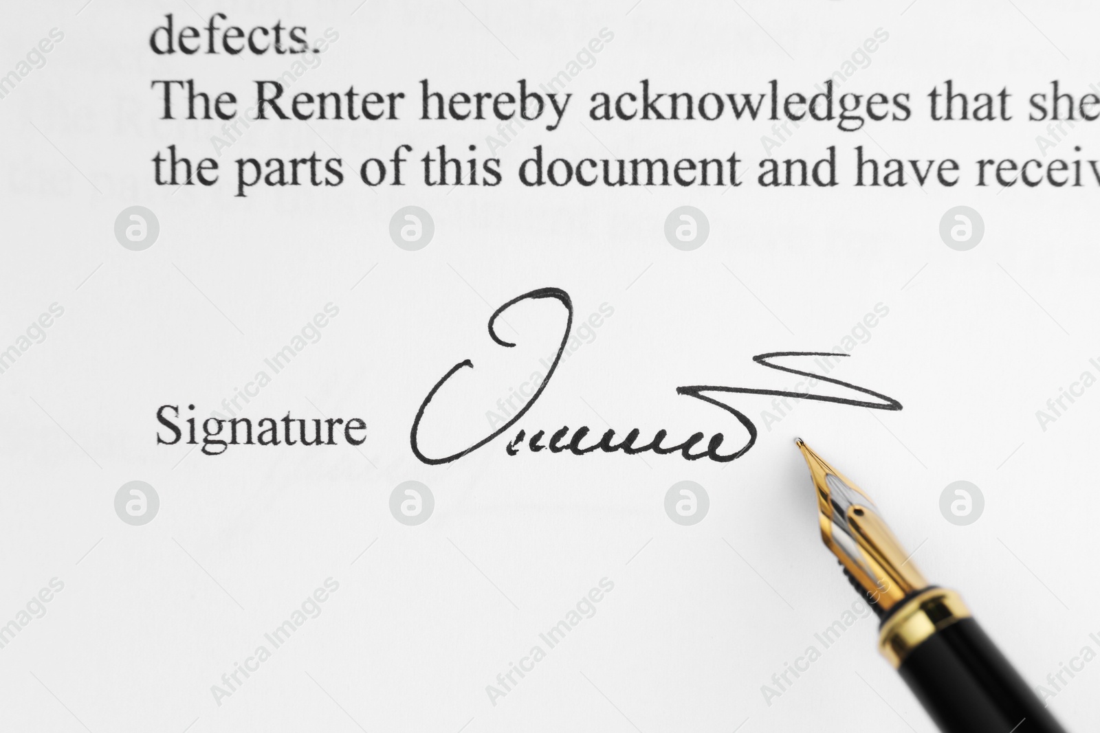 Photo of Fountain pen leaving signature on contract, top view