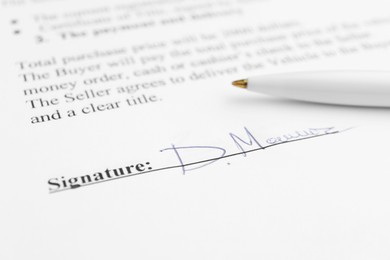 Photo of Ballpoint pen and signature on contract, closeup