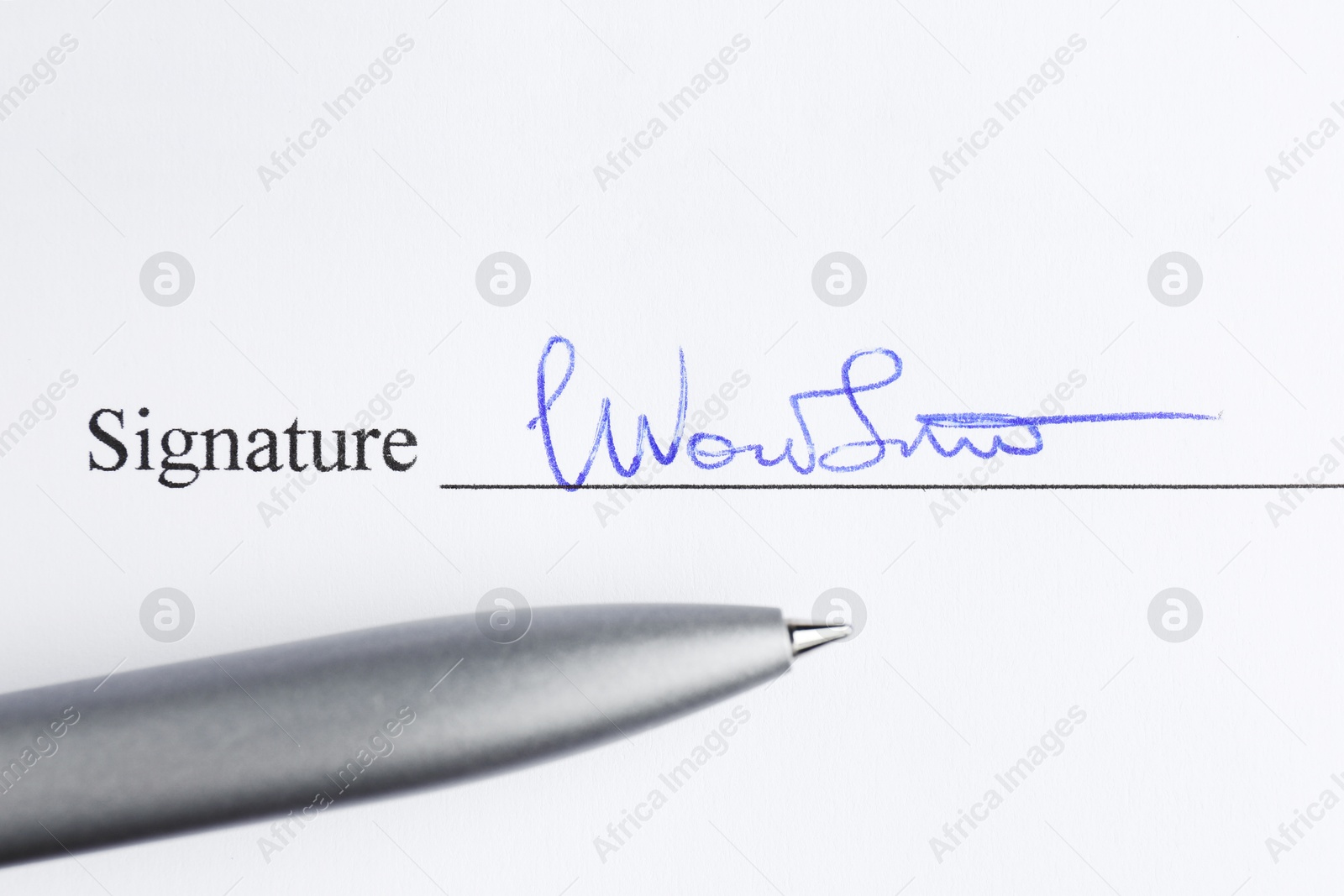 Photo of Ballpoint pen and signature on contract, top view