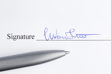 Photo of Ballpoint pen and signature on contract, top view