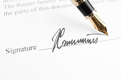 Photo of Fountain pen leaving signature on contract, closeup