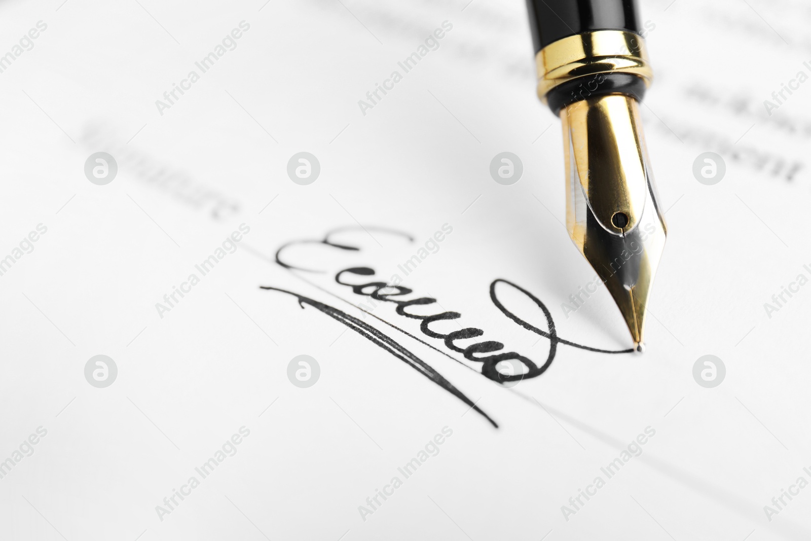 Photo of Fountain pen leaving signature on contract, closeup