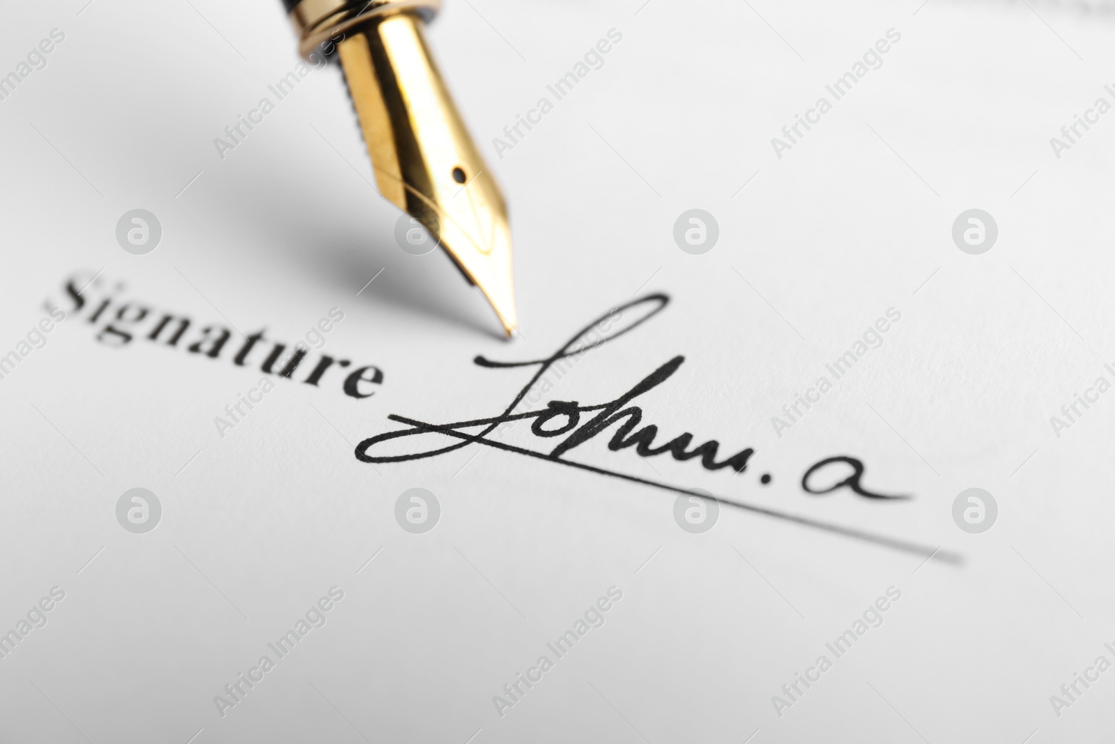 Photo of Fountain pen leaving signature on contract, closeup