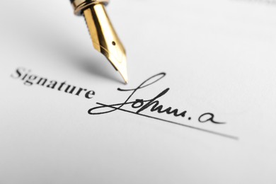 Photo of Fountain pen leaving signature on contract, closeup