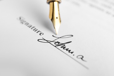 Photo of Fountain pen leaving signature on contract, closeup