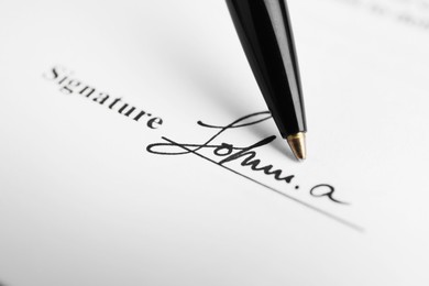 Photo of Ballpoint pen and signature on contract, closeup