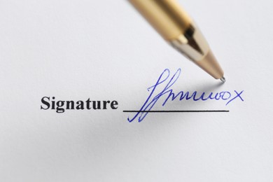 Photo of Pen leaving signature on contract, top view