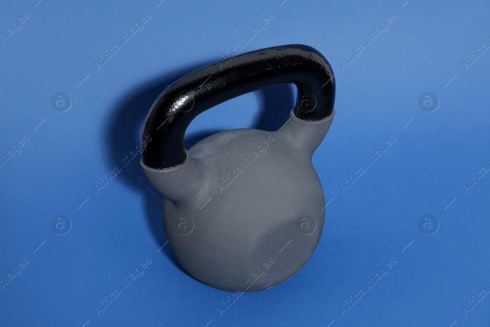 Photo of One kettlebell on blue background. Sport equipment