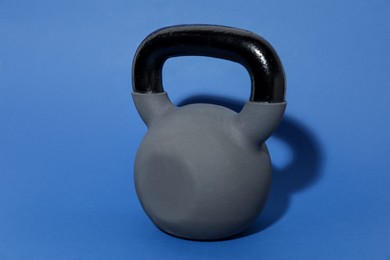 Photo of One kettlebell on blue background. Sport equipment