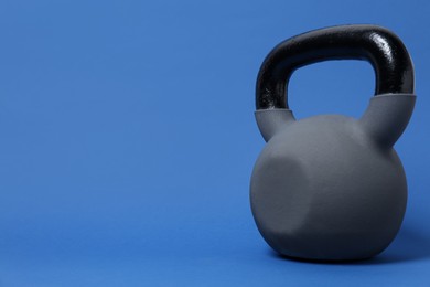 Photo of One kettlebell on blue background. Space for text