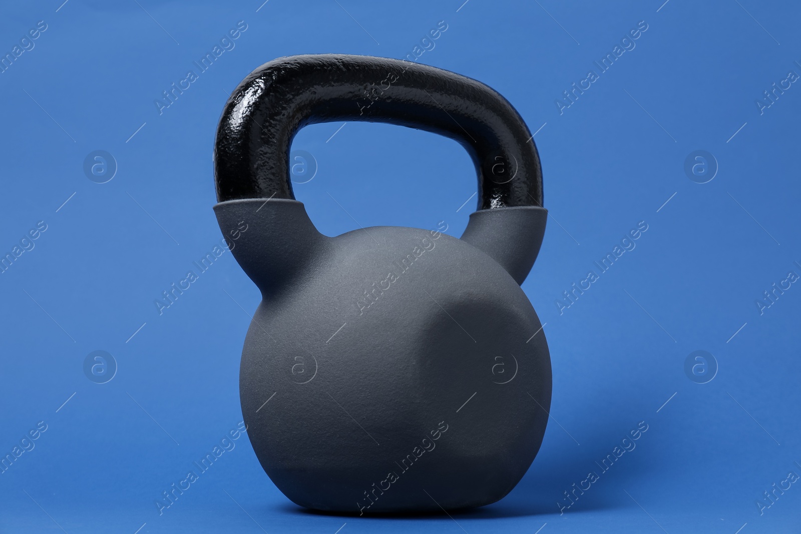 Photo of One kettlebell on blue background. Sport equipment