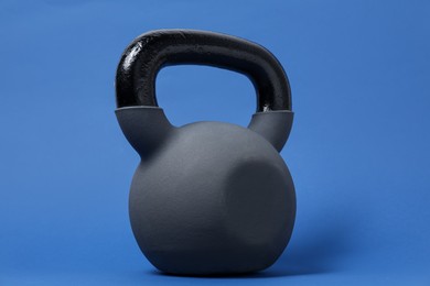 Photo of One kettlebell on blue background. Sport equipment