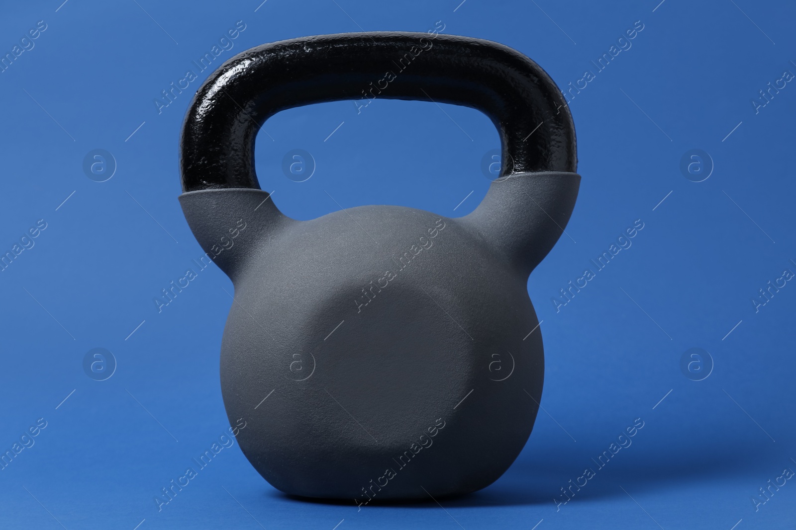 Photo of One kettlebell on blue background. Sport equipment