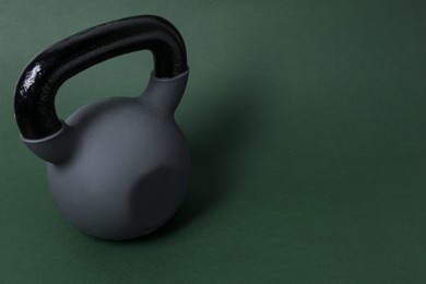 Photo of One kettlebell on dark green background. Space for text