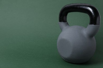 Photo of One kettlebell on dark green background. Space for text