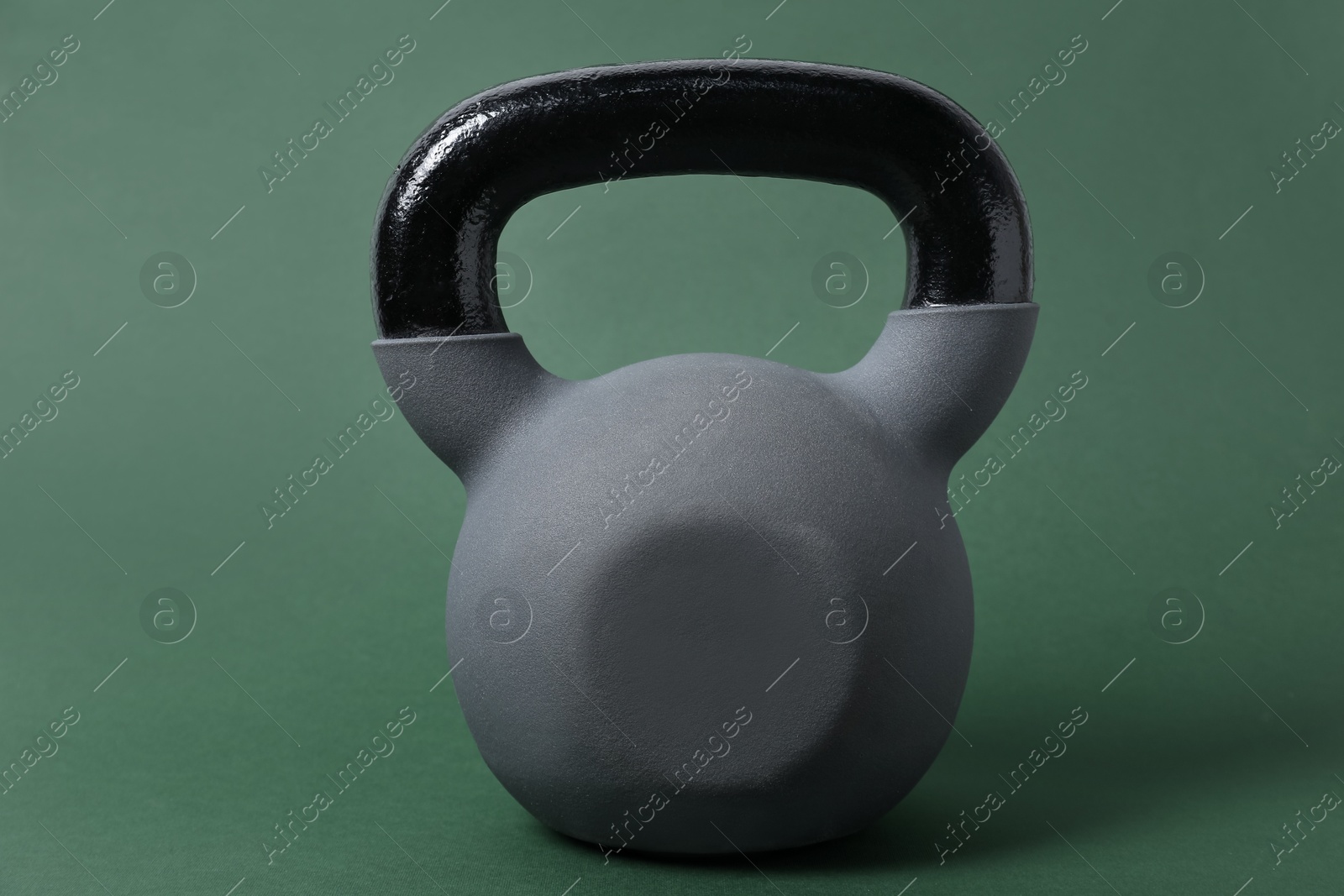 Photo of One kettlebell on dark green background. Sport equipment