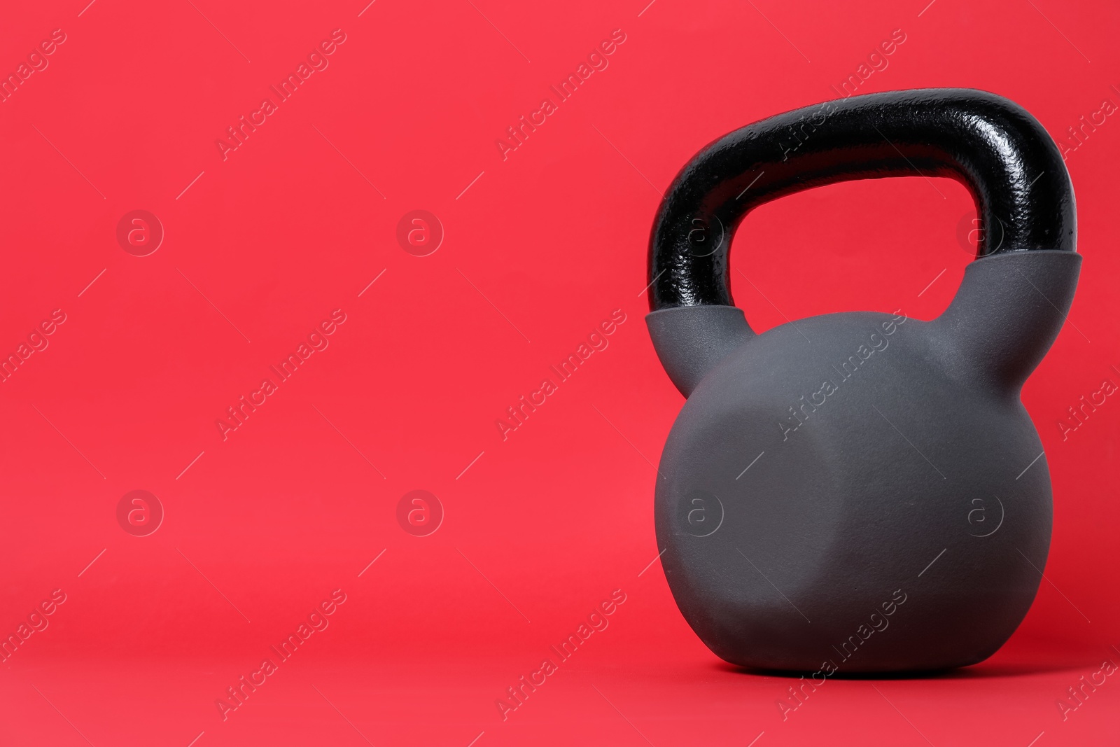 Photo of One kettlebell on red background. Space for text