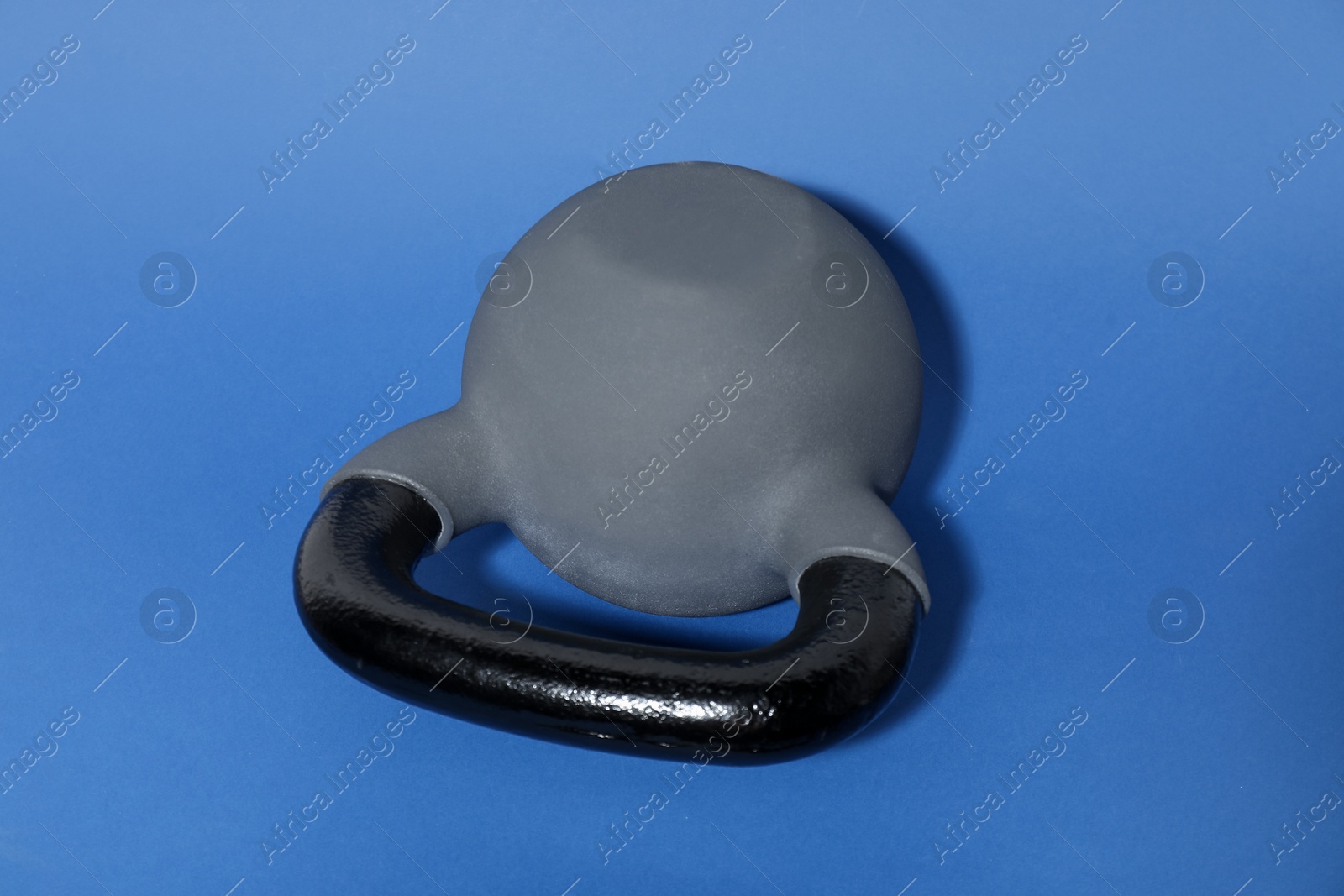 Photo of One kettlebell on blue background. Sport equipment