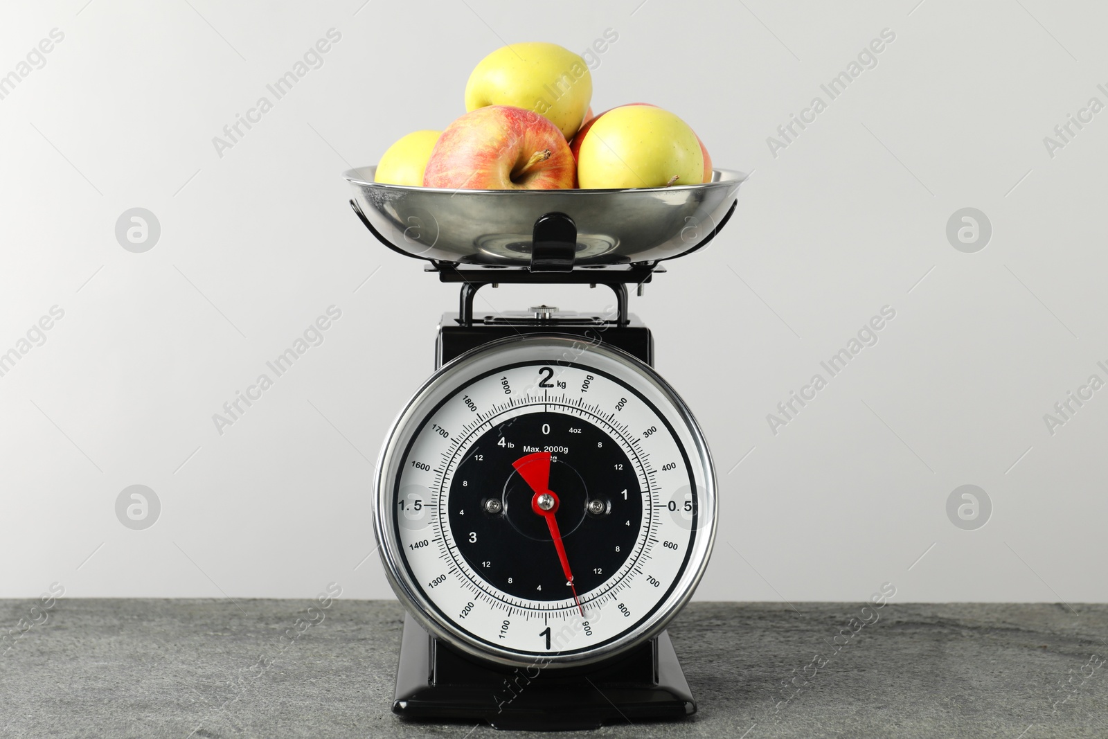 Photo of Retro mechanical kitchen scale with apples on grey table