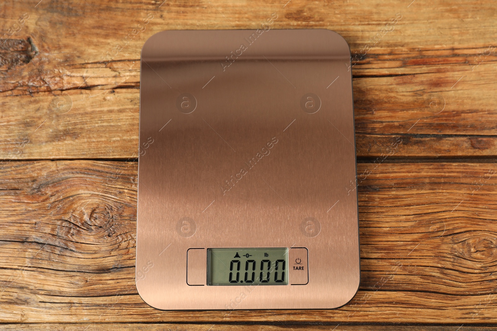 Photo of Modern electronic kitchen scale on wooden table, top view