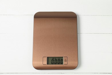 Photo of Modern electronic kitchen scale on white wooden table, top view