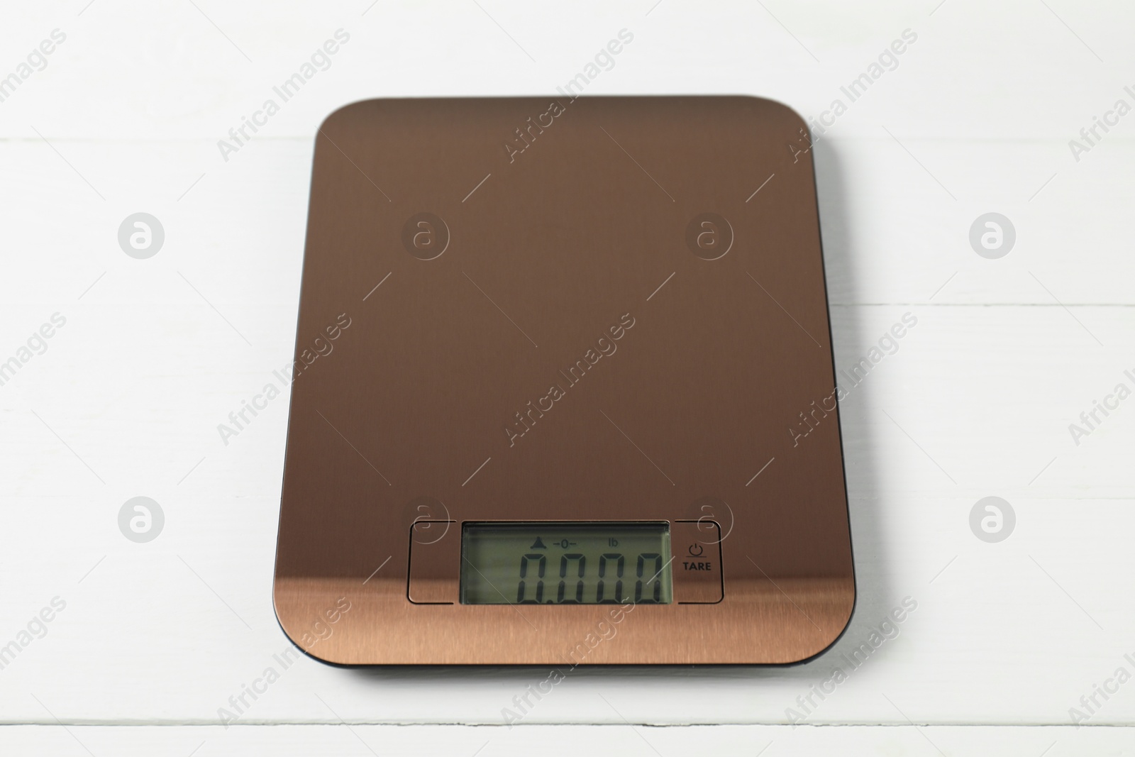 Photo of Modern electronic kitchen scale on white wooden table, closeup