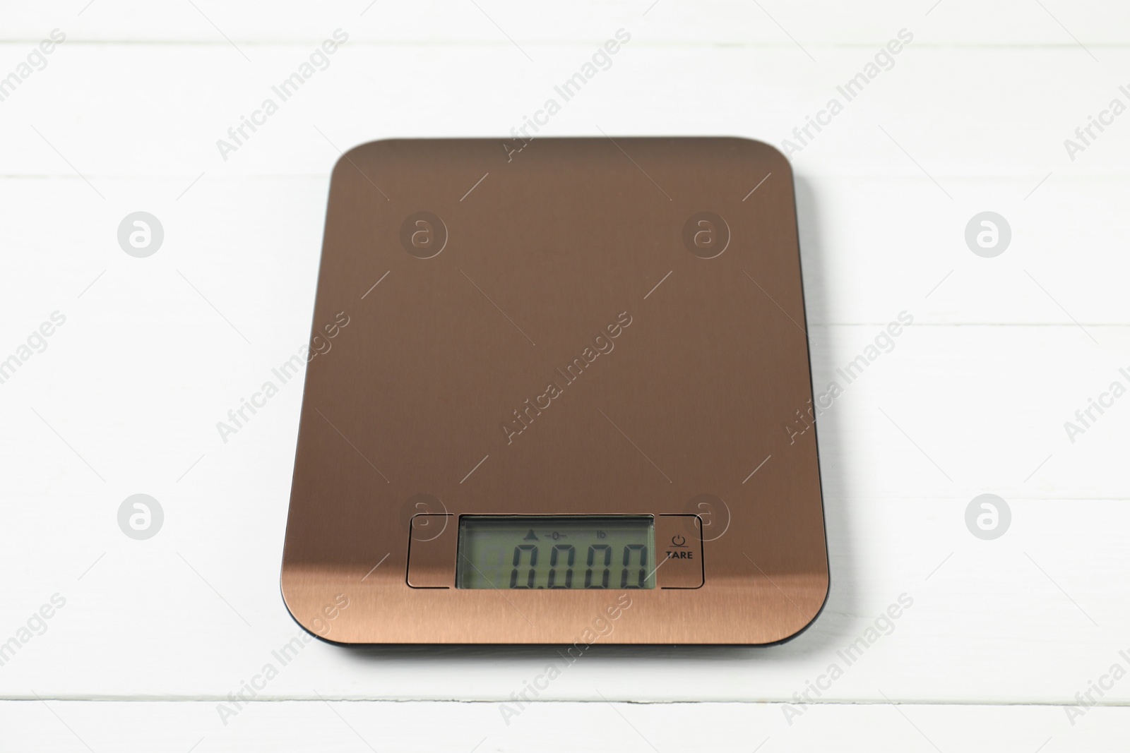 Photo of Modern electronic kitchen scale on white wooden table, closeup