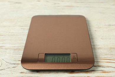 Photo of Modern electronic kitchen scale on wooden table, closeup