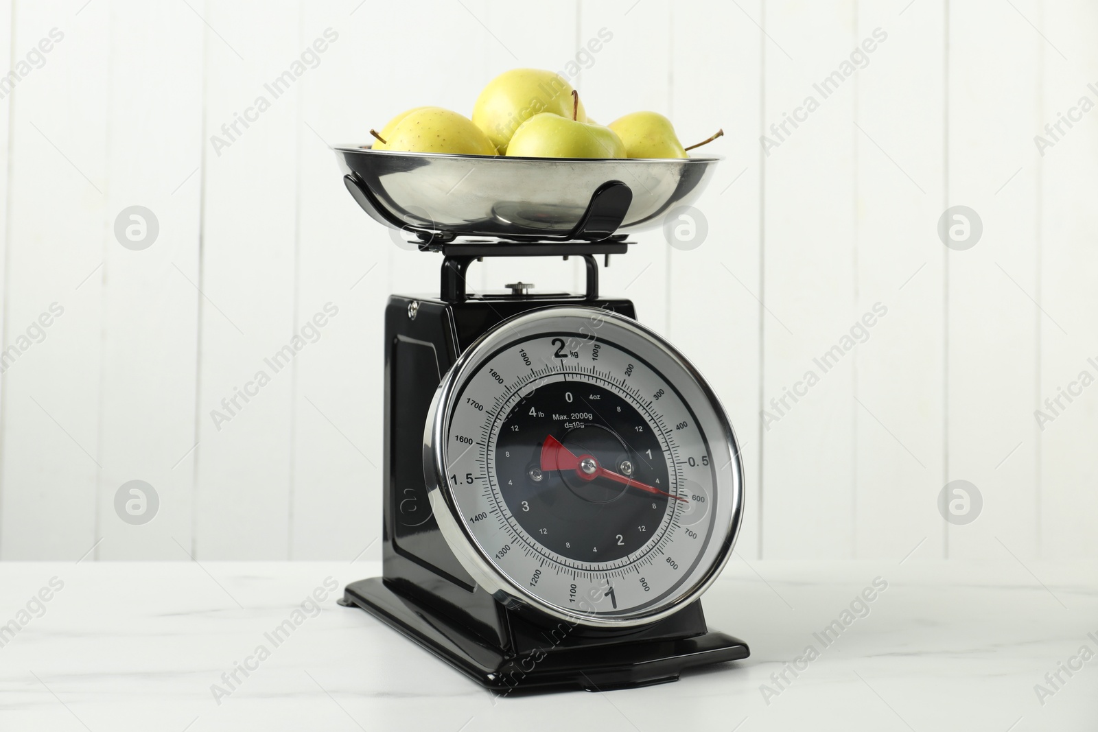 Photo of Retro mechanical kitchen scale with apples on white marble table