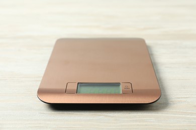 Photo of Modern electronic kitchen scale on wooden table, closeup