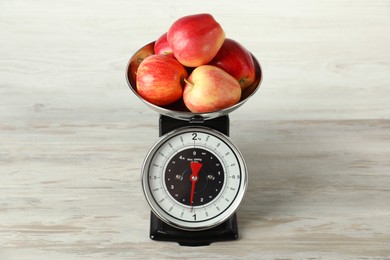 Photo of Retro mechanical kitchen scale with apples on wooden table