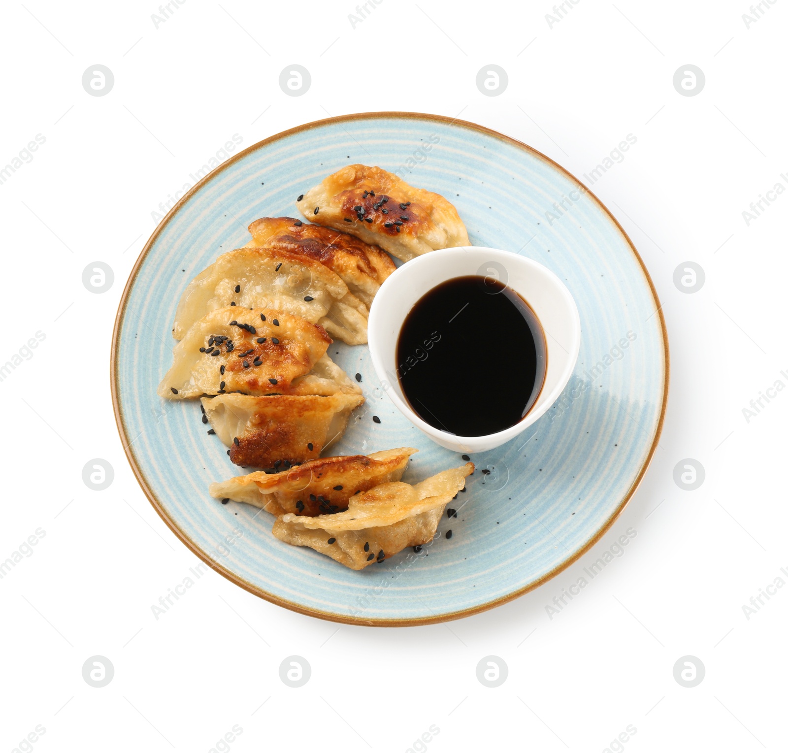 Photo of Tasty fried gyoza (dumplings) and soy sauce isolated on white, top view