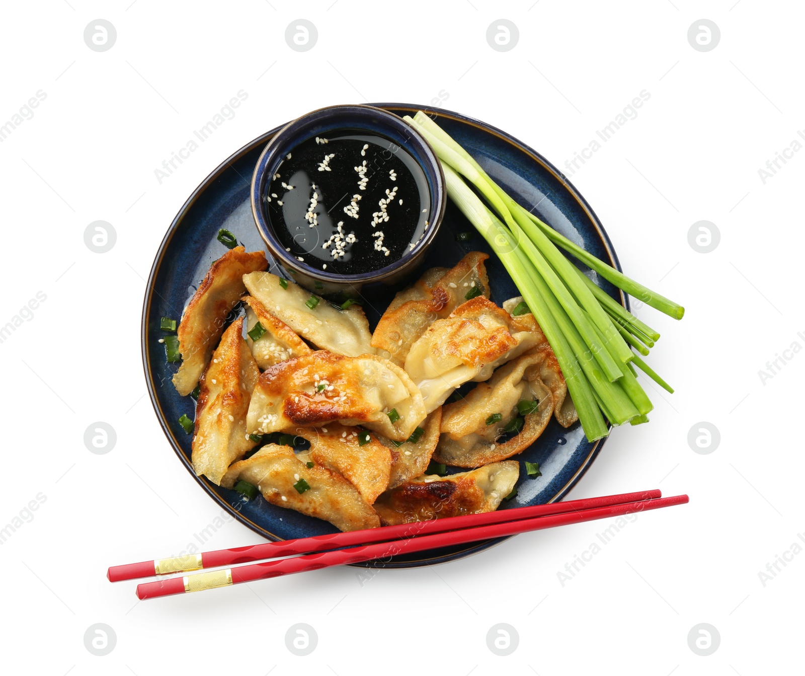 Photo of Tasty fried gyoza (dumplings), onion, chopsticks and soy sauce isolated on white, top view