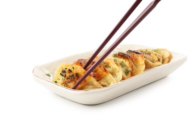 Photo of Taking tasty fried gyoza (dumpling) with chopsticks isolated on white