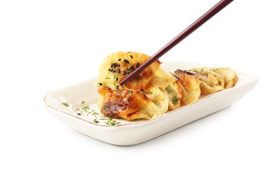 Photo of Taking tasty fried gyoza (dumpling) with chopsticks isolated on white