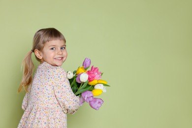 Photo of Smiling little girl with bouquet of tulips on green background. Space for text