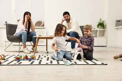 Photo of Hyperactive children playing and their overwhelmed parents at home