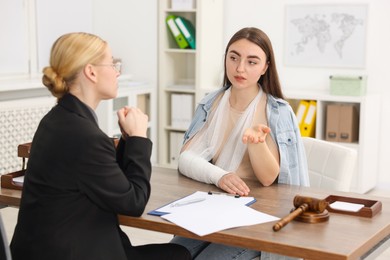 Photo of Injured woman having meeting with lawyer in office