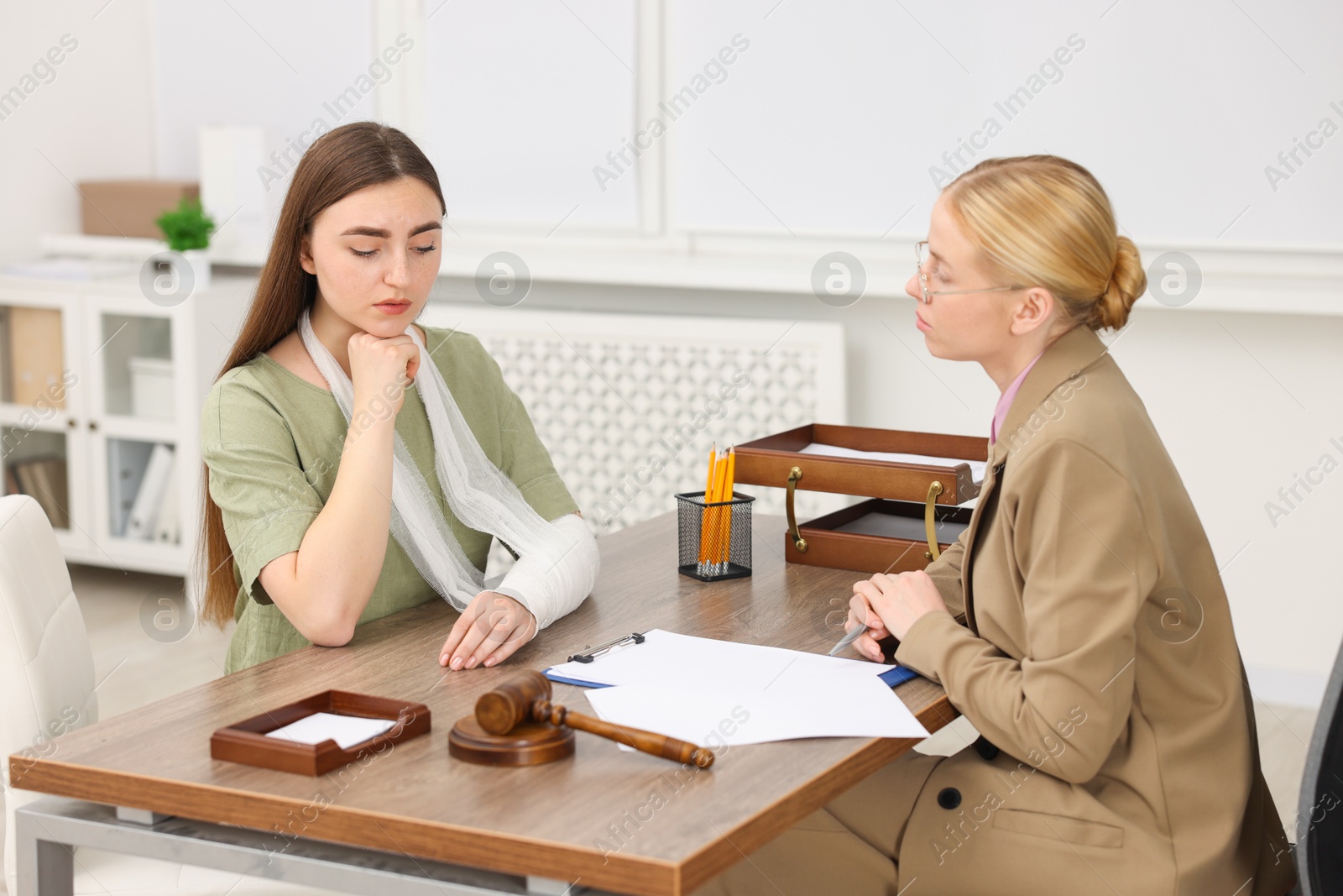 Photo of Injured woman having meeting with lawyer in office