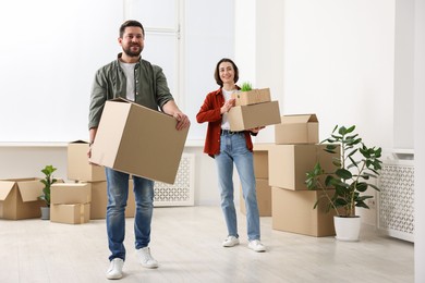 Photo of Moving day. Happy couple with their belongings in new home